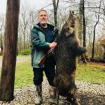 Happy hunter with his trophy hog, trophy hog hunts